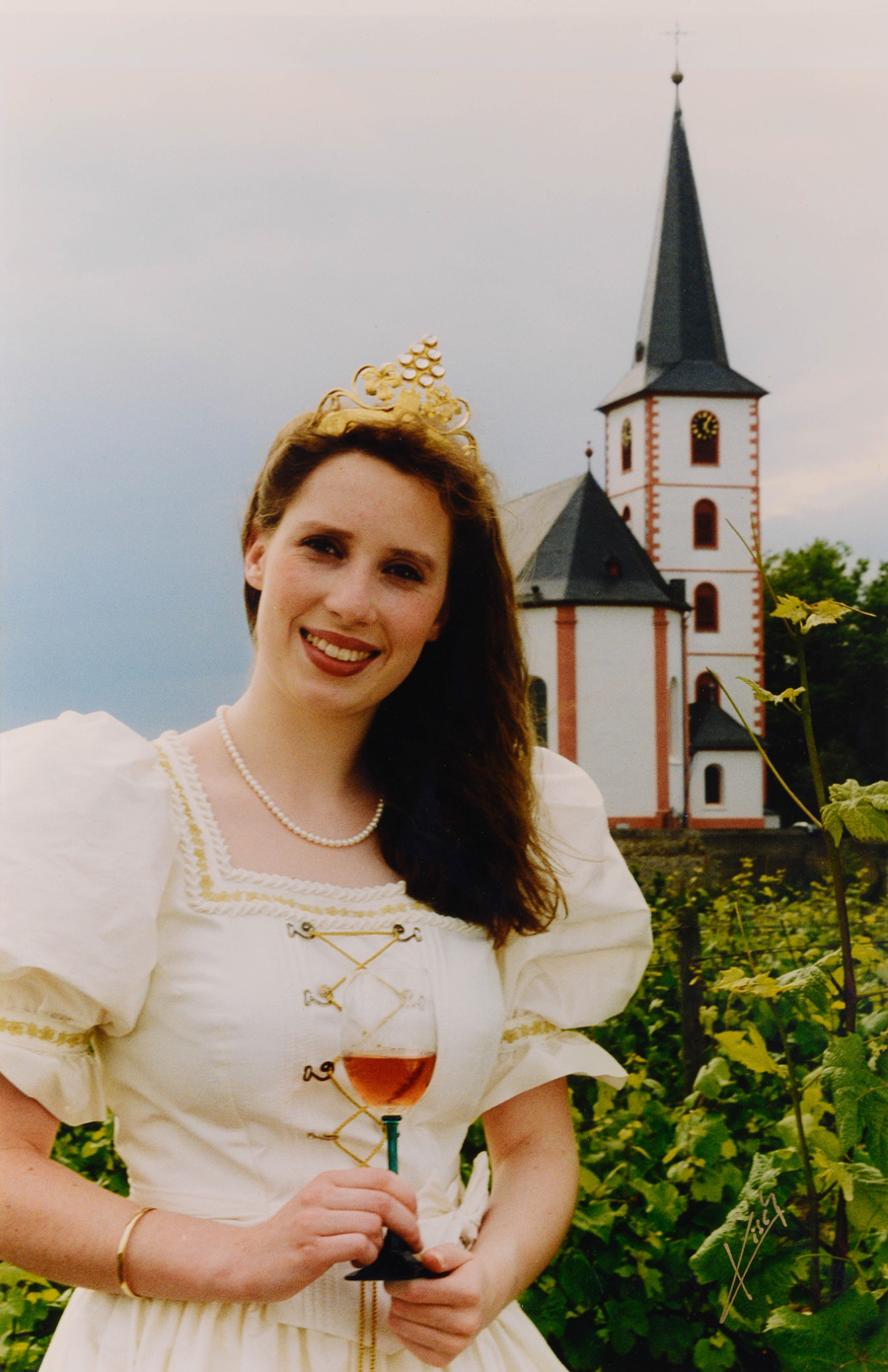 Weinkönigin Kerstin Koschnitzki (1999-2000) mit dem Hochheimer Wahrzeichen der Pfarrkirche St. Peter und Paul im Hintergrund.