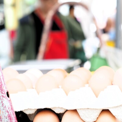 Am Stand "Britta Bringt's" des Hochheimer Wochenmarktes sind frische Eier in verschiedenen Größen und Farben zu sehen, die von regionalen Bauernhöfen stammen.
